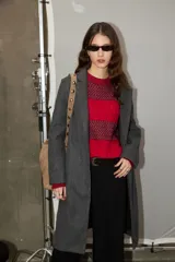 Sweater de tejido jacquard con diseño de rayas horizontales en tonos rojo y bordó, de corte holgado, cuello redondo y manga larga.