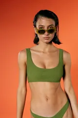 Top de bikini verde militar con textura arrugada, escote amplio y breteles fijos. Incluye bombacha vedetina con frente en V.