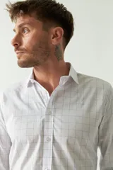 Camisa de hombre de corte slim fit, confeccionada en algodón con diseño de rayas verticales finas en tonos claros. Presenta cuello clásico, cierre frontal con botones y logo bordado en el pecho.