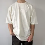 Remera oversize color marfil, de mangas cortas amplias y corte holgado. Presenta un pequeño estampado frontal con texto bordó que dice "Vcp Collection".