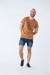 Bermuda de jean azul con lavado clásico, diseño de cinco bolsillos, cierre de cremallera y botón, con detalle de botamanga doblada.