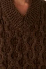 Chaleco de punto color crema con diseño trenzado y cuello en V.