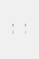 Pack de cuatro pendientes metálicos dorados. Incluye un par de aros pequeños con relieve y un par de pendientes tipo tachuela con forma alargada y aplicación de cristal central.