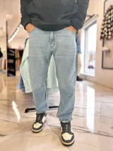 Jeans mom fit de corte holgado en color celeste claro, con diseño de talle alto y botamangas ajustadas con elástico.