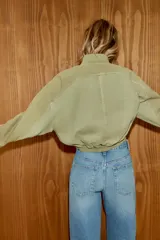 Jeans de tiro alto con diseño de pierna ancha y corte extra largo. Presenta una cintura cruzada asimétrica con cierre de cremallera y botones metálicos, además de un diseño clásico de cinco bolsillos.