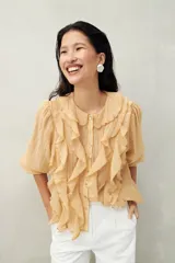 Camisa blanca de tencel liviana con cuello babero, volados románticos y manga larga. De caída suave y textura aireada.