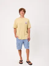 Remera Rusty de corte holgado, color amarillo, con estampa en la espalda de un personaje surfeando sobre un pez y textos descriptivos.