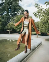 Tapado marrón de cuero con corte a la rodilla, mangas largas y aberturas laterales.