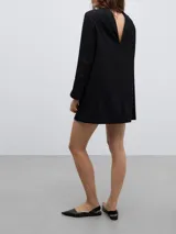 Vestido mini de línea recta en color negro, con cuello solapa y manga larga. Presenta un diseño minimalista y estructurado.