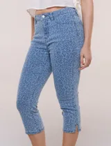 Pantalón capri de tiro medio y calce ajustado confeccionado en denim elastizado con diseño animal print al tono, bolsillos delanteros y traseros.