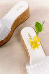 Sandalia con plataforma de corcho y capellada tejida de cuero vacuno.