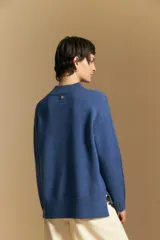 Polera de tejido de punto color blanco, con cuello alto acanalado, hombros caídos y detalle de costura vertical en el frente.