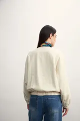 Chaqueta tipo bomber color negro, con cierre frontal metálico, cuello redondo y puños elásticos.