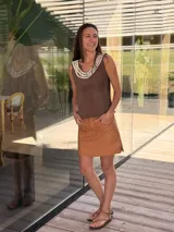 Musculosa marrón de cuero con cuello redondo adornado con caracoles cosidos a mano.