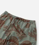 Bermuda de baño para hombre, color verde salvia con estampado de palmeras y vegetación en tono marrón. Posee cintura elástica con cordón de ajuste marrón y calzoncillo interior de malla.