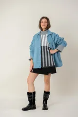 Campera de jean oversize color azul claro, con cuello camisero, cierre frontal con botones y bolsillos frontales. Presenta un diseño de corte amplio y cómodo con mangas largas.