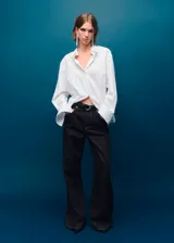 Pantalón de jean estilo wide leg de tiro medio, con diseño de cinco bolsillos, trabillas para cinturón y cierre frontal con botones.