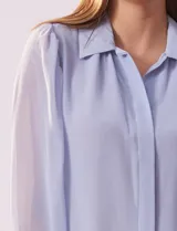 Camisa blanca de gasa marca Tahari, con cuello con solapa y abertura central con botones ocultos. Manga larga con puño y botones.