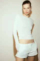 Top de punto fino semitransparente con cuello redondo y manga larga, de corte ajustado.