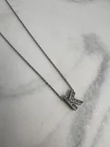 Collar de acero quirúrgico plateado con dije de letra F incrustado de strass.