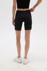 Short de poliamida color marrón chocolate, de calce medio y al cuerpo, con cintura alta y textura acanalada.