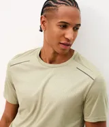 Remera deportiva de hombre Get Over color verde militar, de corte regular y cuello redondo. Confeccionada en tejido texturizado con tecnología dry, presenta detalles reflectantes en los hombros.