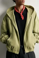 Cazadora relaxed fit de hombre, confeccionada en tejido estructurado tipo waffle con efecto lavado en color verde. Cuenta con cuello con capucha, cierre frontal con cremallera, bolsillos frontales tipo canguro y acabados elásticos en puños y bajo.
