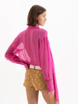 Camisa Brooklyn de gasa en color fucsia, confeccionada en seda y viscosa. Presenta mangas largas con puños abotonados, cierre frontal con botones y un elegante lazo integrado en el cuello.