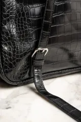 Mochila midi negra con detalles en color ladrillo y beige con textura símil piel de cocodrilo.