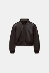 Chaqueta tipo bomber de piel con cuello alto, manga larga con hombreras y puños elásticos. Presenta bolsillos delanteros, bajo elástico y cierre frontal con cremallera y botones ocultos por solapa.