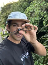 Gorro tipo gorra de visera plana, con paneles a rayas verticales azules y blancas, y visera blanca lisa. Presenta bordado en la parte frontal con el texto "LEVEIN", "MOOD THAT ONLY KNOW" y "SEE GOOD FIALN THINGS".