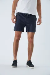 Short de baño de color azul marino, con cintura elástica ajustable mediante cordón, bolsillos laterales y bolsillo trasero. Cuenta con suspensor interno y logo bordado.