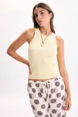 Musculosa de punto a la base, color amarillo, con cuello redondo y diseño ajustado.