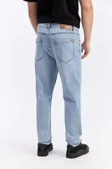 Jean de corte slim, color celeste con sutil efecto lavado, tiro medio y diseño clásico de cinco bolsillos.