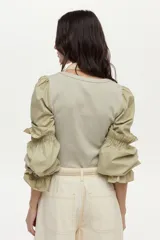 Blusa de rib y popelina color blanco, con calce al cuerpo, escote cuadrado y mangas voluminosas con volados.