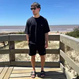 Remera negra tejida con cuello redondo y manga corta, con logo bordado en el pecho.