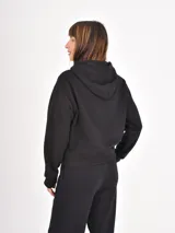 Campera negra con capucha, cierre frontal completo y cordones ajustables. Presenta un diseño liso y funcional con bolsillos laterales.