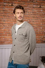 Overshirt de lana melange en color gris, con cuello camisero, cierre frontal de botones y dos bolsillos frontales con solapa.