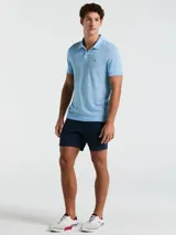 Polo celeste con textura jaspeada, cuello clásico, manga corta y logo bordado en el pecho.