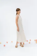 Vestido largo de lino con escote en V, diseño recto y fluido, con cierre frontal abotonado mediante botones de madera.