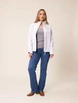 Campera softshell blanca con cierre frontal completo, cuello alto y bolsillos laterales. Presenta un bolsillo vertical con cierre en el pecho y el logo de la marca bordado.