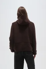 Campera tipo duffle coat de lana en color verde oliva, con capucha, cierre frontal mediante botones tipo toggle y bolsillos delanteros con solapa.