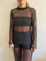 Polera de red negra con cuello alto y mangas largas.