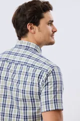 Camisa de manga corta con estampado de cuadros en tonos azules, rojos y blancos, cuello con botones y bolsillo ojal en el pecho con logo bordado.