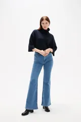 Pantalon de jean azul oscuro con corte flare, tiro alto y bolsillos frontales tipo parche.