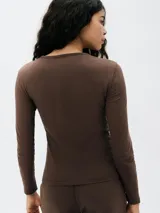 Camiseta de manga larga ajustada al cuerpo, color blanco, con cuello redondo.