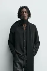 Camisa de corte relajado confeccionada en una mezcla de viscosa y algodón con textura. Presenta cuello solapa, cierre frontal de botones, manga larga con puños abotonados y aberturas laterales en el bajo.