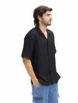 Camisa negra de manga corta, con cuello cubano y corte suelto.