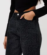 Pantalón de jean con corte recto y largo cropped, de cintura alta. Presenta un diseño estampado con motivo animal print en tonos oscuros, cierre frontal con botón y bolsillos funcionales.