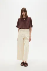 Pantalon de jean estilo barrel, color natural, de tiro medio con bolsillos laterales y cierre frontal.